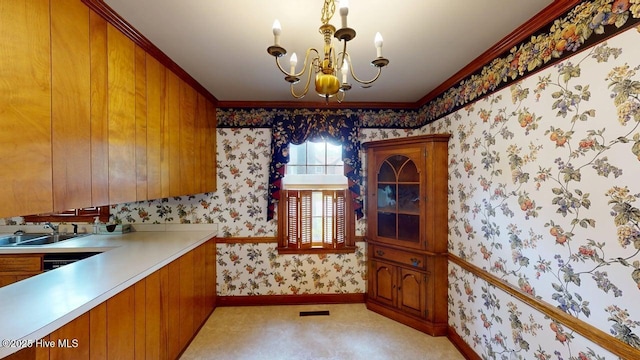 707 S Claiborne St, Goldsboro, NC 27530 - kitchen with a chandelier, brown cabinetry, wallpapered walls, light countertops, and ornamental molding