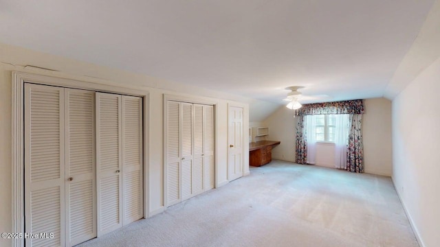 707 S Claiborne St, Goldsboro, NC 27530 - unfurnished bedroom with carpet flooring, lofted ceiling, two closets, and a ceiling fan
