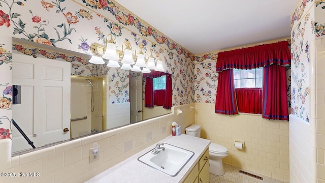 707 S Claiborne St, Goldsboro, NC 27530 - bathroom featuring wallpapered walls, a shower with door, a wainscoted wall, vanity, and tile walls