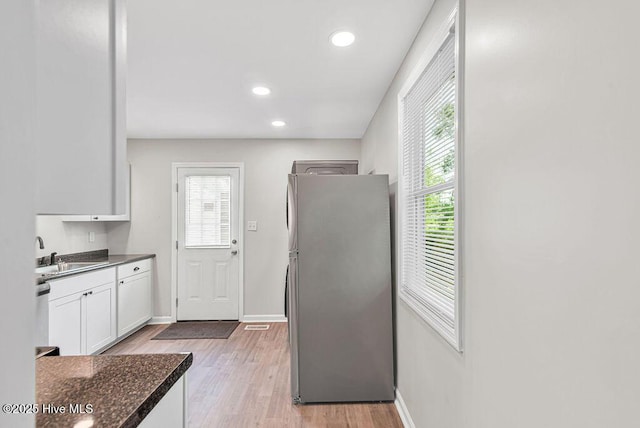 721 New River Dr, Jacksonville, NC 28540 - kitchen with freestanding refrigerator, white cabinets, plenty of natural light, light wood finished floors, and recessed lighting