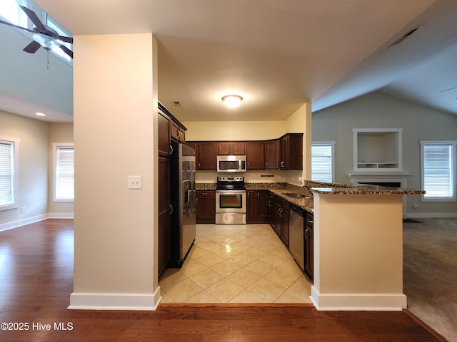 205 Channel Marker Loop, Swansboro, NC 28584 - kitchen with appliances with stainless steel finishes, a ceiling fan, dark stone counters, vaulted ceiling, and dark brown cabinets
