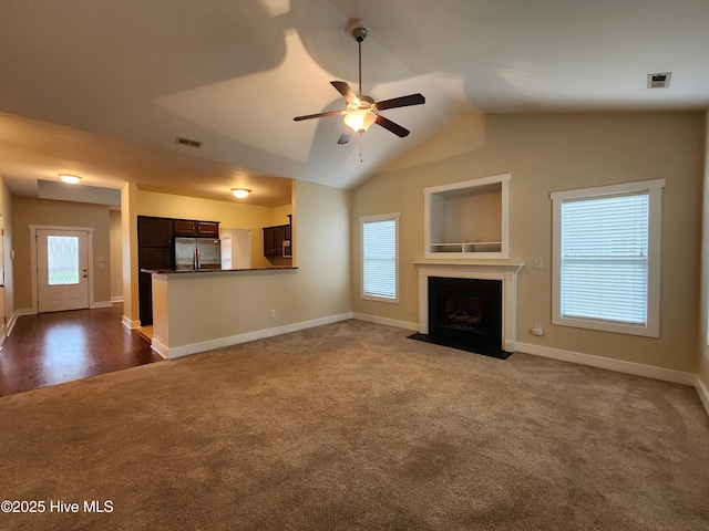205 Channel Marker Loop, Swansboro, NC 28584 - unfurnished living room with dark colored carpet, ceiling fan, plenty of natural light, a fireplace with flush hearth, and lofted ceiling