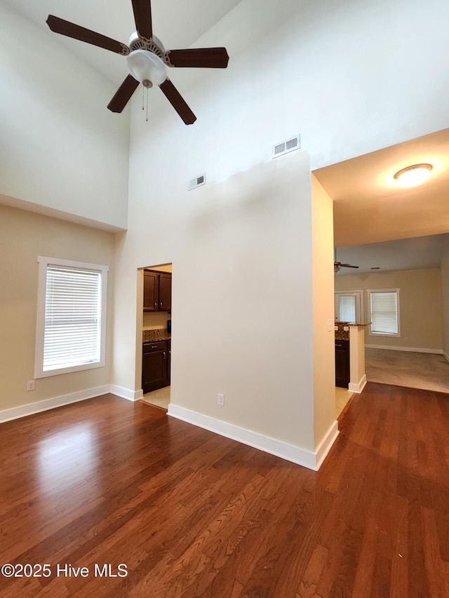 205 Channel Marker Loop, Swansboro, NC 28584 - unfurnished living room featuring a ceiling fan, wood finished floors, and a high ceiling