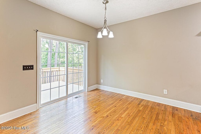 3 S Ct, Pinehurst, NC 28374 - spare room with light wood finished floors, a chandelier, and a textured ceiling