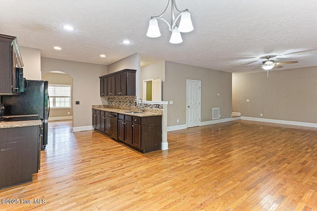 3 S Ct, Pinehurst, NC 28374 - kitchen with arched walkways, black microwave, dark brown cabinetry, dishwasher, and light wood-style flooring
