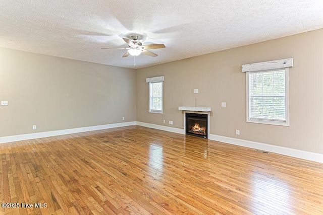 3 S Ct, Pinehurst, NC 28374 - unfurnished living room featuring light wood-style floors, plenty of natural light, a ceiling fan, and a textured ceiling