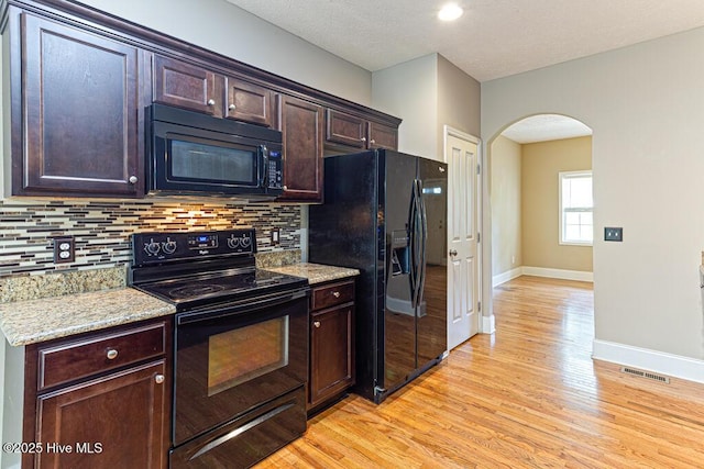 3 S Ct, Pinehurst, NC 28374 - kitchen featuring black appliances, arched walkways, light wood finished floors, backsplash, and dark brown cabinets