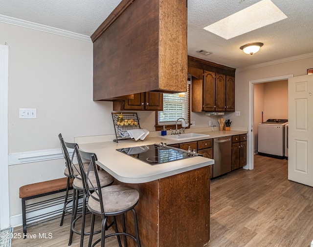 306 Goldleaf Dr, Goldsboro, NC 27534 - kitchen featuring washer / dryer, black electric stovetop, dishwasher, a textured ceiling, and light wood-style flooring