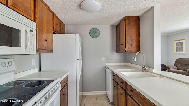 800 Saint Andrews Dr # 156, Pinehurst, NC 28374 - kitchen featuring white appliances, a textured ceiling, light countertops, light tile patterned floors, and brown cabinetry