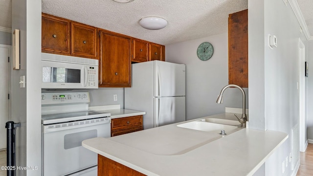 800 Saint Andrews Dr # 156, Pinehurst, NC 28374 - kitchen featuring white appliances, light countertops, a textured ceiling, and brown cabinets
