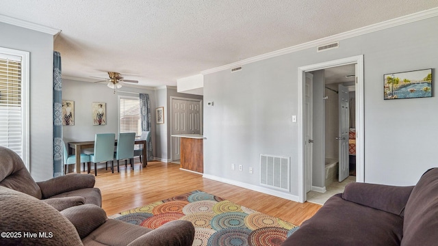 800 Saint Andrews Dr # 156, Pinehurst, NC 28374 - living room with light wood-style floors, crown molding, a ceiling fan, and a textured ceiling