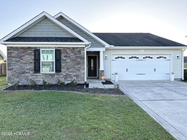 939 Dynamo Ln, Jacksonville, NC 28546 - view of front of house with stone siding, a front yard, driveway, a garage, and roof with shingles