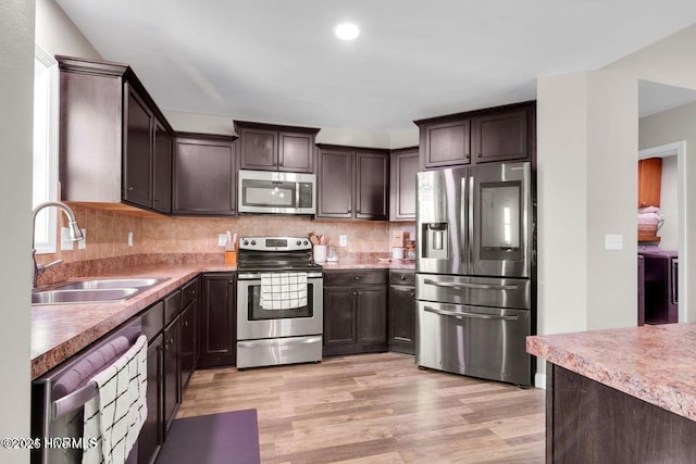 939 Dynamo Ln, Jacksonville, NC 28546 - kitchen with appliances with stainless steel finishes, dark brown cabinets, light wood finished floors, backsplash, and recessed lighting