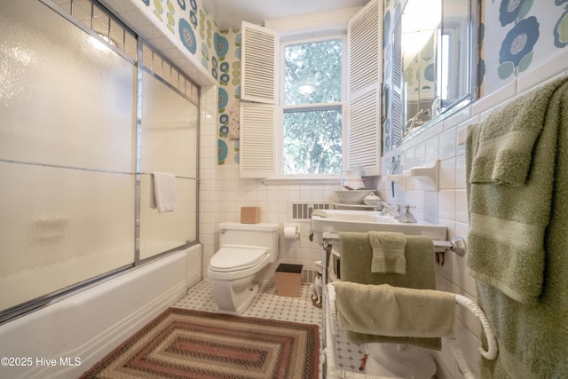 900 Nash St N, Wilson, NC 27893 - bathroom with plenty of natural light, tile walls, bath / shower combo with glass door, and tile patterned flooring