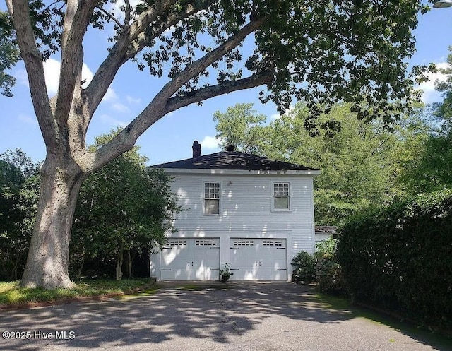 900 Nash St N, Wilson, NC 27893 - view of side of property featuring a chimney, an attached garage, and driveway