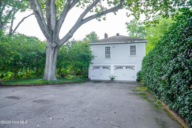 900 Nash St N, Wilson, NC 27893 - view of side of property featuring a garage, a chimney, and asphalt driveway