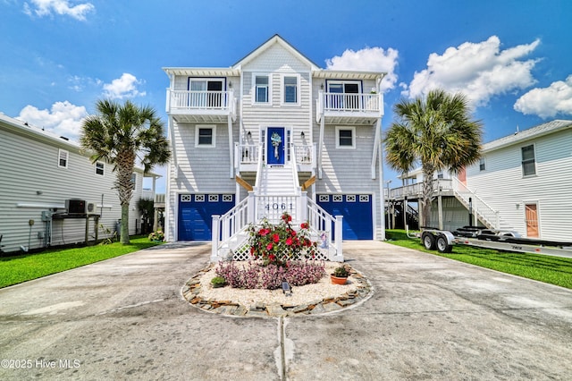 4061 4th St, Surf City, NC 28445 - coastal inspired home featuring a balcony, stairs, concrete driveway, and a garage