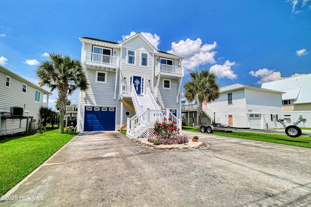 4061 4th St, Surf City, NC 28445 - view of front of home with a balcony, driveway, a garage, stairway, and a front lawn