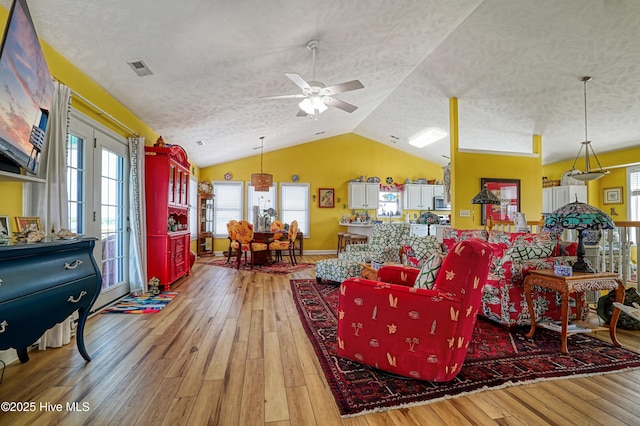 4061 4th St, Surf City, NC 28445 - living area featuring a textured ceiling, light wood-style floors, vaulted ceiling, ceiling fan, and plenty of natural light