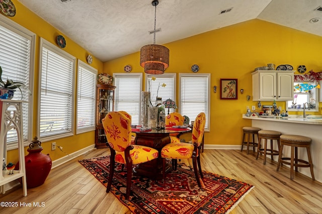 4061 4th St, Surf City, NC 28445 - dining space featuring lofted ceiling, light wood-type flooring, and a chandelier