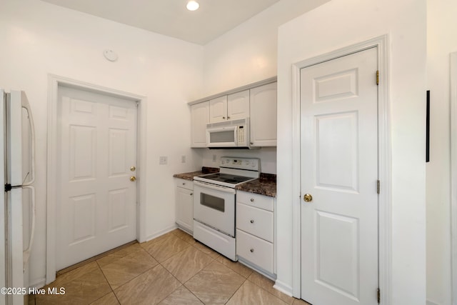 32 S Shelby Rd, Southport, NC 28461 - kitchen featuring white appliances, dark countertops, and white cabinetry