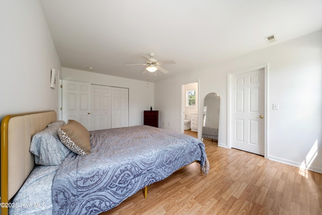 32 S Shelby Rd, Southport, NC 28461 - bedroom featuring light wood-style flooring, arched walkways, a closet, ceiling fan, and ensuite bath