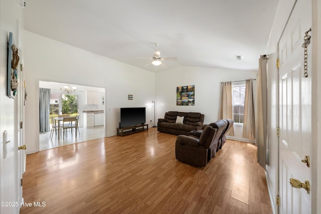 32 S Shelby Rd, Southport, NC 28461 - living room featuring lofted ceiling, wood finished floors, ceiling fan, plenty of natural light, and a chandelier