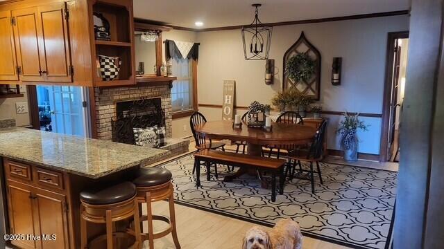 2262 Old Oak Rd, Kinston, NC 28504 - dining area featuring ornamental molding, light wood-style flooring, a fireplace, and recessed lighting