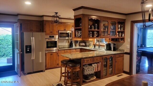 2262 Old Oak Rd, Kinston, NC 28504 - kitchen featuring appliances with stainless steel finishes, open shelves, crown molding, brown cabinets, and light stone counters