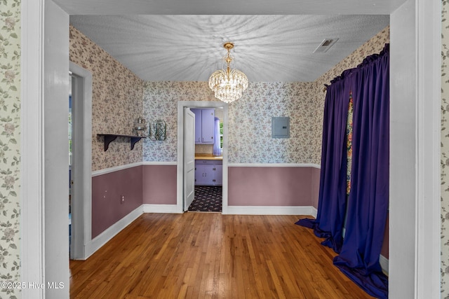 1710 National Ave, New Bern, NC 28560 - unfurnished dining area with a chandelier, hardwood / wood-style flooring, wallpapered walls, and electric panel
