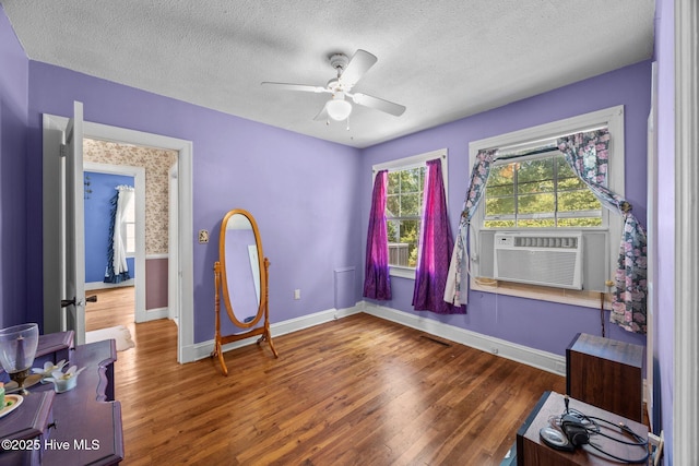 1710 National Ave, New Bern, NC 28560 - unfurnished bedroom with wood finished floors, a textured ceiling, cooling unit, and ceiling fan
