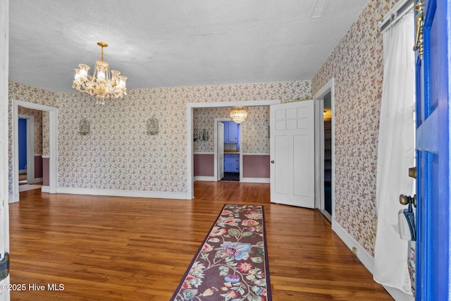 1710 National Ave, New Bern, NC 28560 - foyer entrance with wallpapered walls, a chandelier, wood finished floors, and a textured ceiling