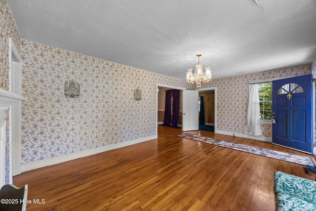 1710 National Ave, New Bern, NC 28560 - foyer with wallpapered walls, a chandelier, hardwood / wood-style flooring, and a textured ceiling