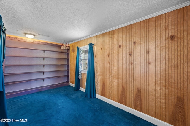 1710 National Ave, New Bern, NC 28560 - spare room with ornamental molding, a textured ceiling, carpet, and wooden walls