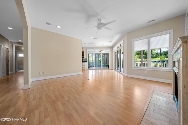 2945 Moorings Way SE, Southport, NC 28461 - unfurnished living room with a fireplace with flush hearth, light wood-type flooring, a ceiling fan, and recessed lighting