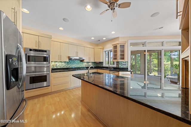 2945 Moorings Way SE, Southport, NC 28461 - kitchen with appliances with stainless steel finishes, under cabinet range hood, a warming drawer, dark stone countertops, and tasteful backsplash