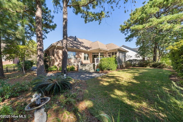 2945 Moorings Way SE, Southport, NC 28461 - back of property featuring a lawn, a sunroom, and brick siding