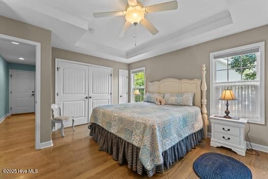 124 Juniper Creek Blvd Unit 16, Pinehurst, NC 28374 - bedroom with a raised ceiling, light wood-type flooring, and a ceiling fan