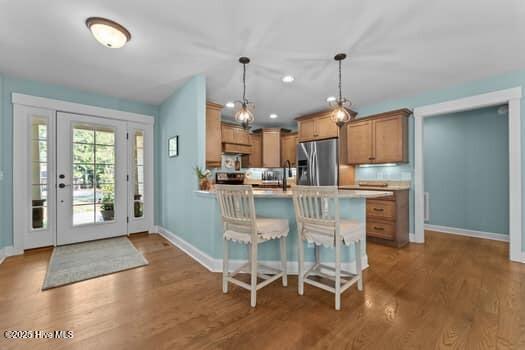 124 Juniper Creek Blvd Unit 16, Pinehurst, NC 28374 - kitchen with stainless steel refrigerator with ice dispenser, light countertops, a peninsula, and wood finished floors