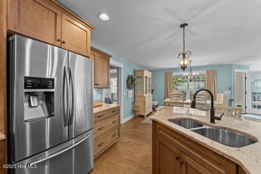 124 Juniper Creek Blvd Unit 16, Pinehurst, NC 28374 - kitchen with stainless steel fridge with ice dispenser, light wood finished floors, pendant lighting, a chandelier, and recessed lighting
