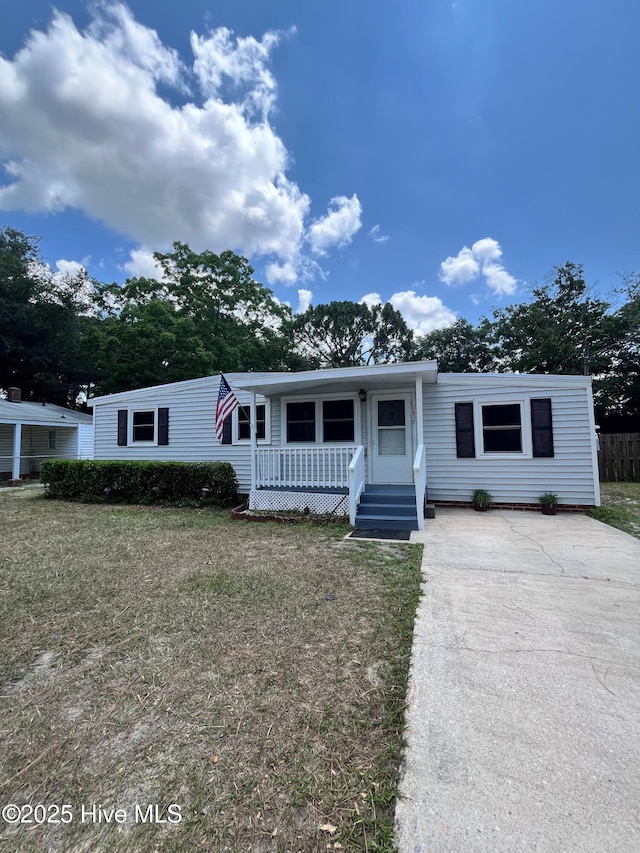 2437 Monroe St, Wilmington, NC 28401 - manufactured / mobile home featuring a porch, driveway, and a front yard
