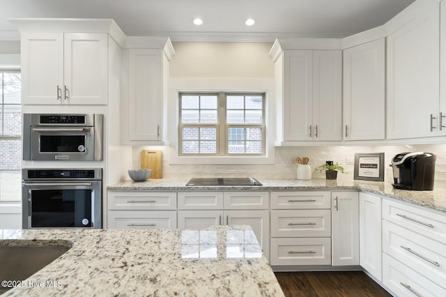 449 Motts Forest Rd Unit 64R, Wilmington, NC 28412 - kitchen with black electric stovetop, white cabinetry, recessed lighting, backsplash, and light stone counters