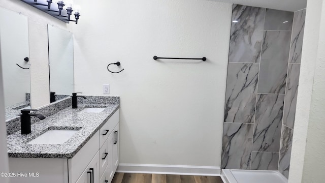702A Richardson St # A, Elizabeth City, NC 27909 - bathroom featuring double vanity, wood finished floors, and tiled shower