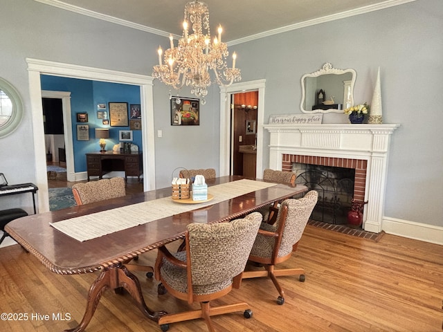 124 W Main St, Woodland, NC 27897 - dining area featuring wood finished floors, a chandelier, a brick fireplace, and crown molding