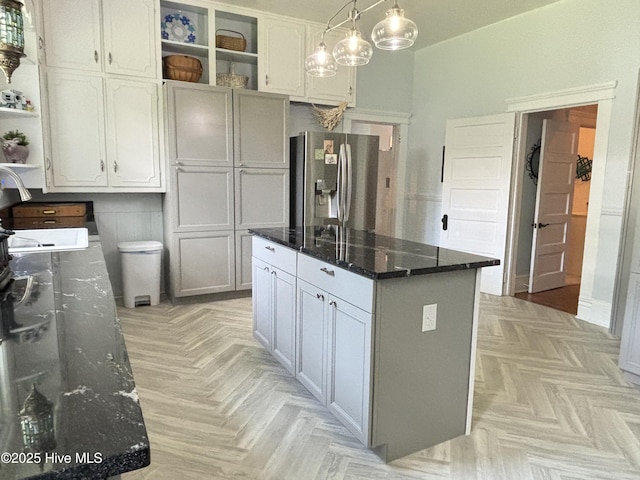 124 W Main St, Woodland, NC 27897 - kitchen with stainless steel fridge with ice dispenser, open shelves, dark stone countertops, white cabinetry, and a center island