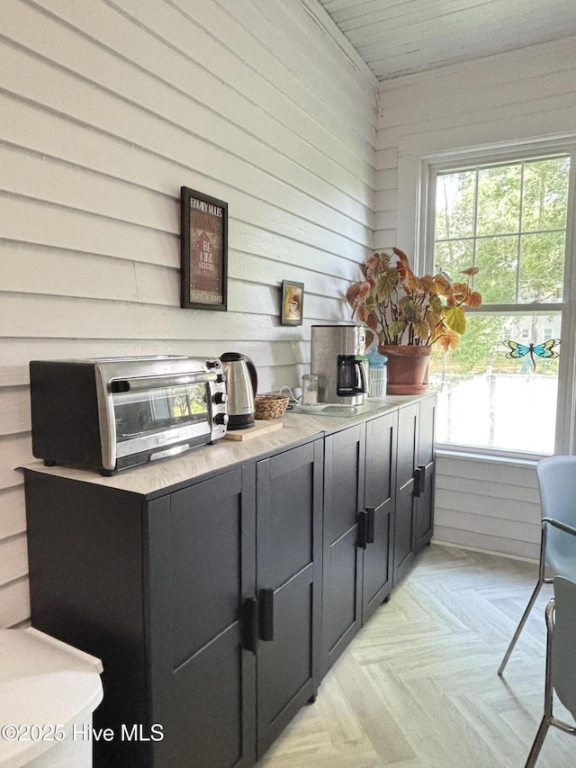 124 W Main St, Woodland, NC 27897 - kitchen with healthy amount of natural light, wooden walls, light countertops, and dark cabinets