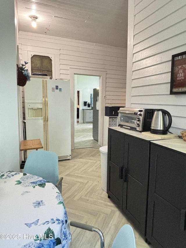 124 W Main St, Woodland, NC 27897 - kitchen with dark cabinets, white refrigerator with ice dispenser, light countertops, and wooden walls