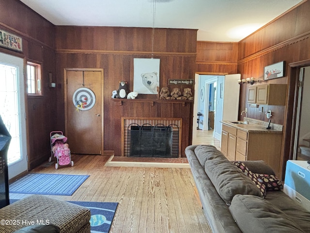 124 W Main St, Woodland, NC 27897 - living room with wood walls, light wood-style floors, and a fireplace