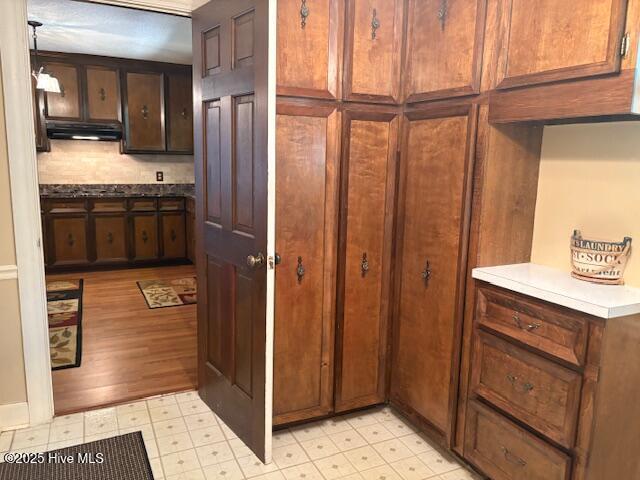 2904 Jason Dr, Rocky Mount, NC 27803 - kitchen featuring under cabinet range hood, light floors, light countertops, and decorative backsplash