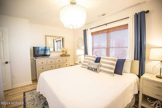 130 Crab St, Holden Beach, NC 28462 - bedroom featuring light wood-style flooring and a chandelier